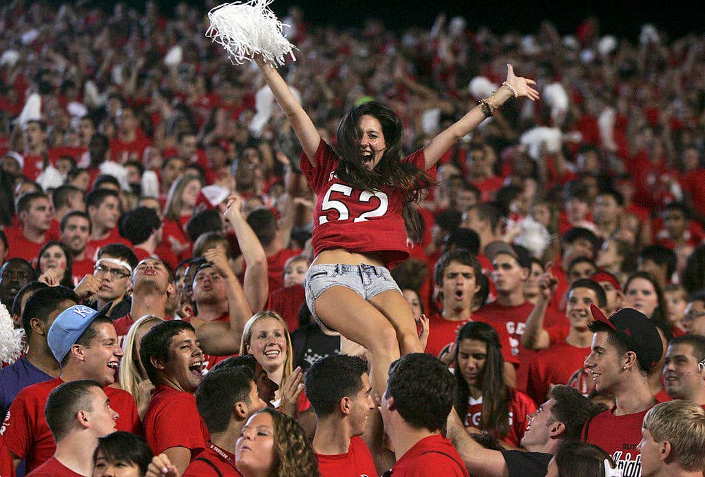 College football fans cheer during a game — not related to candy safety.